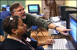 Rose Johnson-Brown, a student in the South Side Community Journalism Workshop, listens as project Managing Editor Chris Long offers advice about the neighborhood news story she is working on.